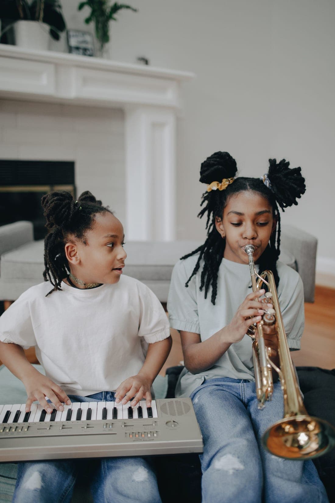 Two children playing a keyboard and a trumpet together